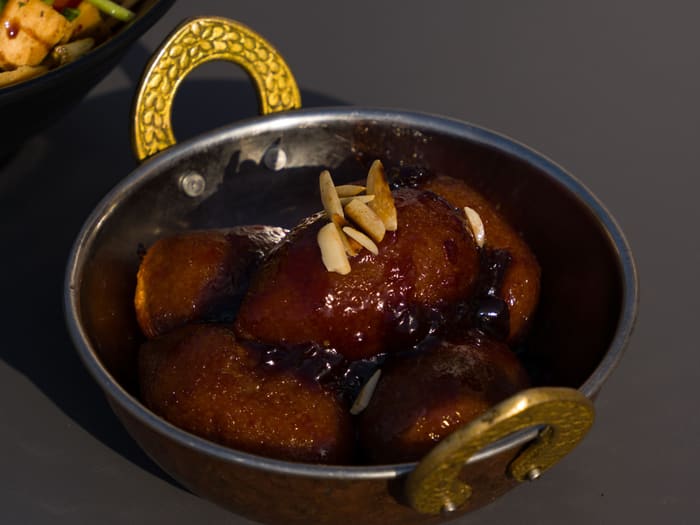 Gulab jamun served in a brass bowl