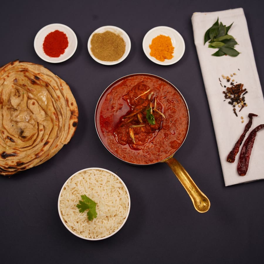 A north Indian feast of curries, rice and breads laid out on a dark table